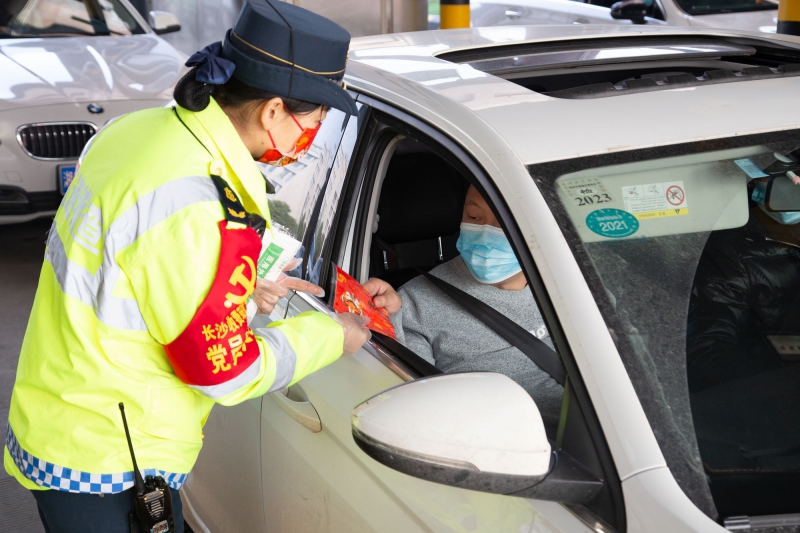 長(zhǎng)沙收費(fèi)站志愿者向乘客贈(zèng)送中國(guó)紅口罩  （周全攝）